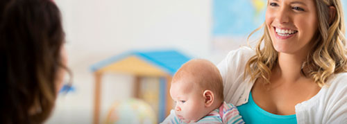 Woman with a baby talking to a daycare provider