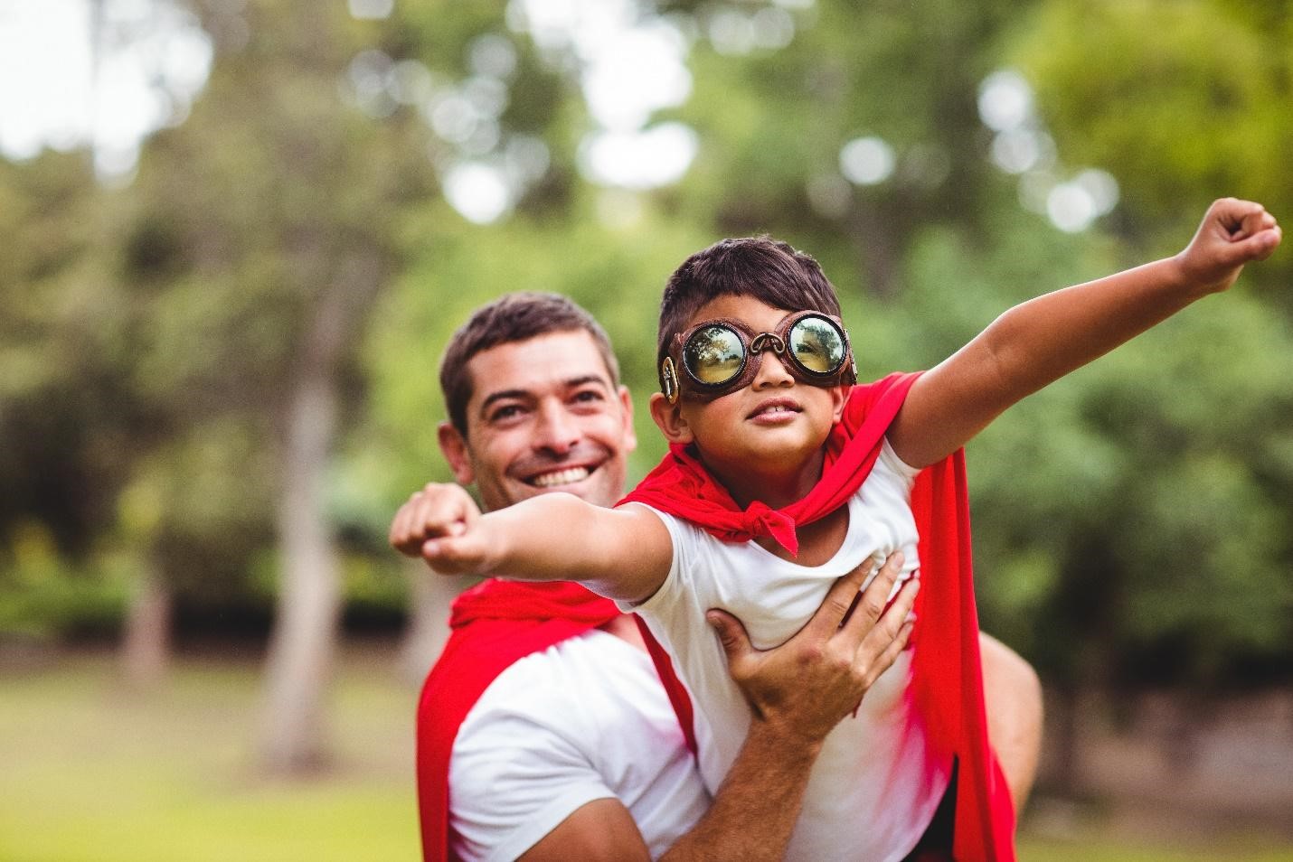 Father and son playing as super heros.