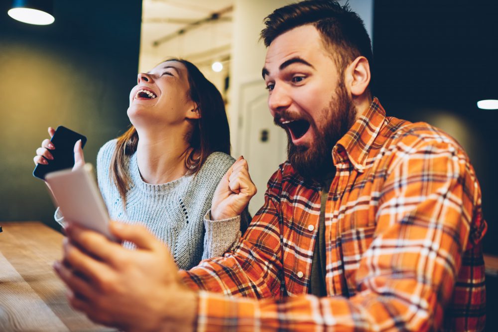 Excited male and femail rejoice in winning an online auction